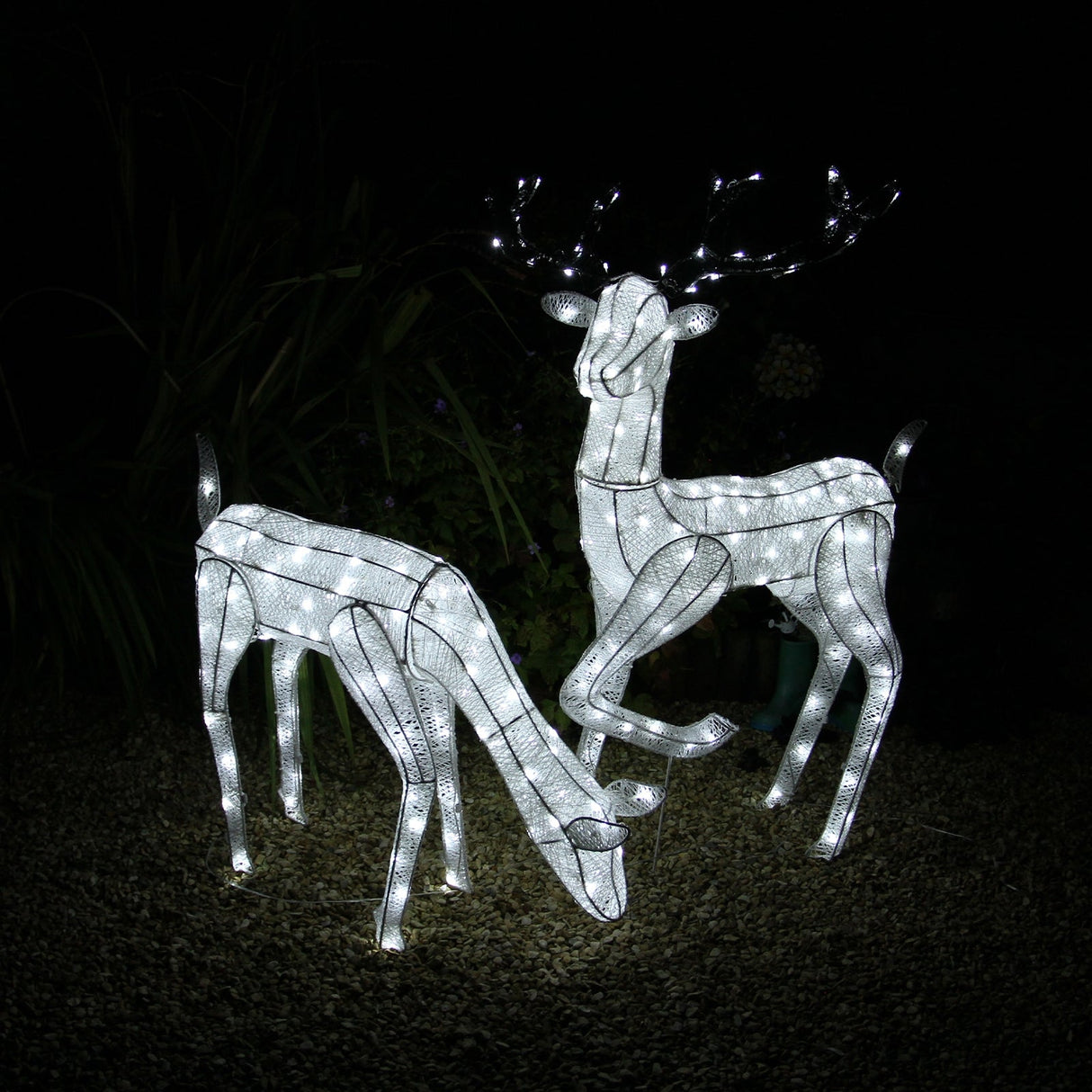 Large illuminated stag and doe reindeer set, featuring a sleek white design with glowing LED lights, perfect for festive decor