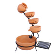 Terracotta 4-tier water feature with cascading bowls, earthy orange color, and a sleek black metal stand, enhancing outdoor decor