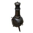 Rustic cast iron chiminea with a tall chimney, textured black finish, and mesh screen, perfect for outdoor warmth and ambiance