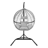 Stylish grey rattan egg chair with a round woven design, plush cushions, and a sturdy black metal stand for indoor or outdoor use