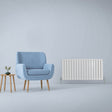 Gloss white designer flat panel radiator, 600mm x 1190mm, sleek and modern, paired with a blue armchair and wooden side table