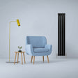 Sleek matt black flat panel radiator stands tall beside a modern blue armchair and stylish yellow lamp in a minimalist room