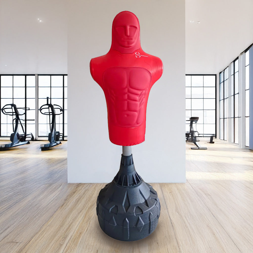 Red free-standing boxing dummy with a muscular torso design, mounted on a sturdy black base, set in a bright gym environment
