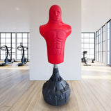 Red free-standing boxing dummy with a muscular torso design, mounted on a sturdy black base, set in a bright gym environment