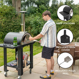 Extra large black pizza oven on a sturdy cart with prep stations, featuring a chimney, rain cover, and pizza peel, set outdoors