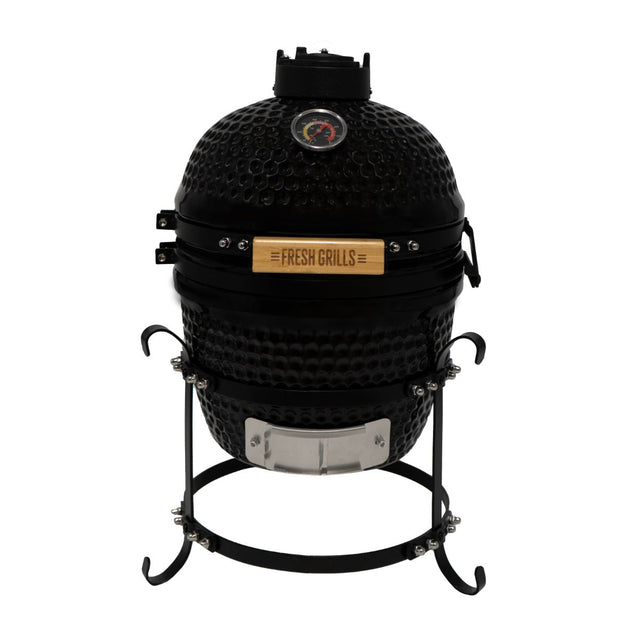 Black ceramic 13" Kamado BBQ oven with a textured surface, metal stand, and wooden handle, featuring a temperature gauge on top