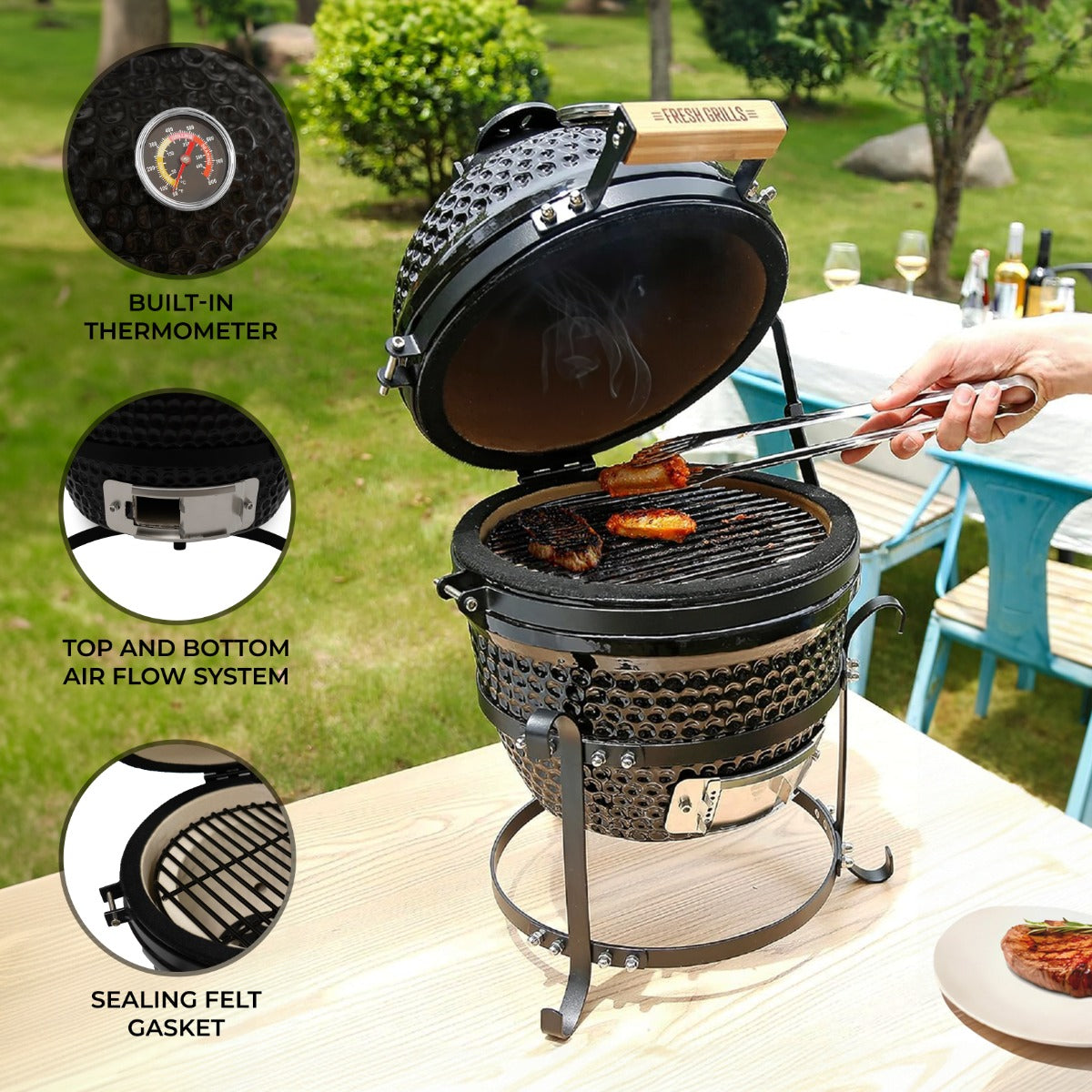 Black ceramic 13" Kamado BBQ oven with a wooden handle, built-in thermometer, and adjustable air flow system, set outdoors with grilled meat