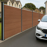 Brown composite fence panels with angled pieces and LED posts, showcasing a smooth wood-like texture and modern design along a driveway