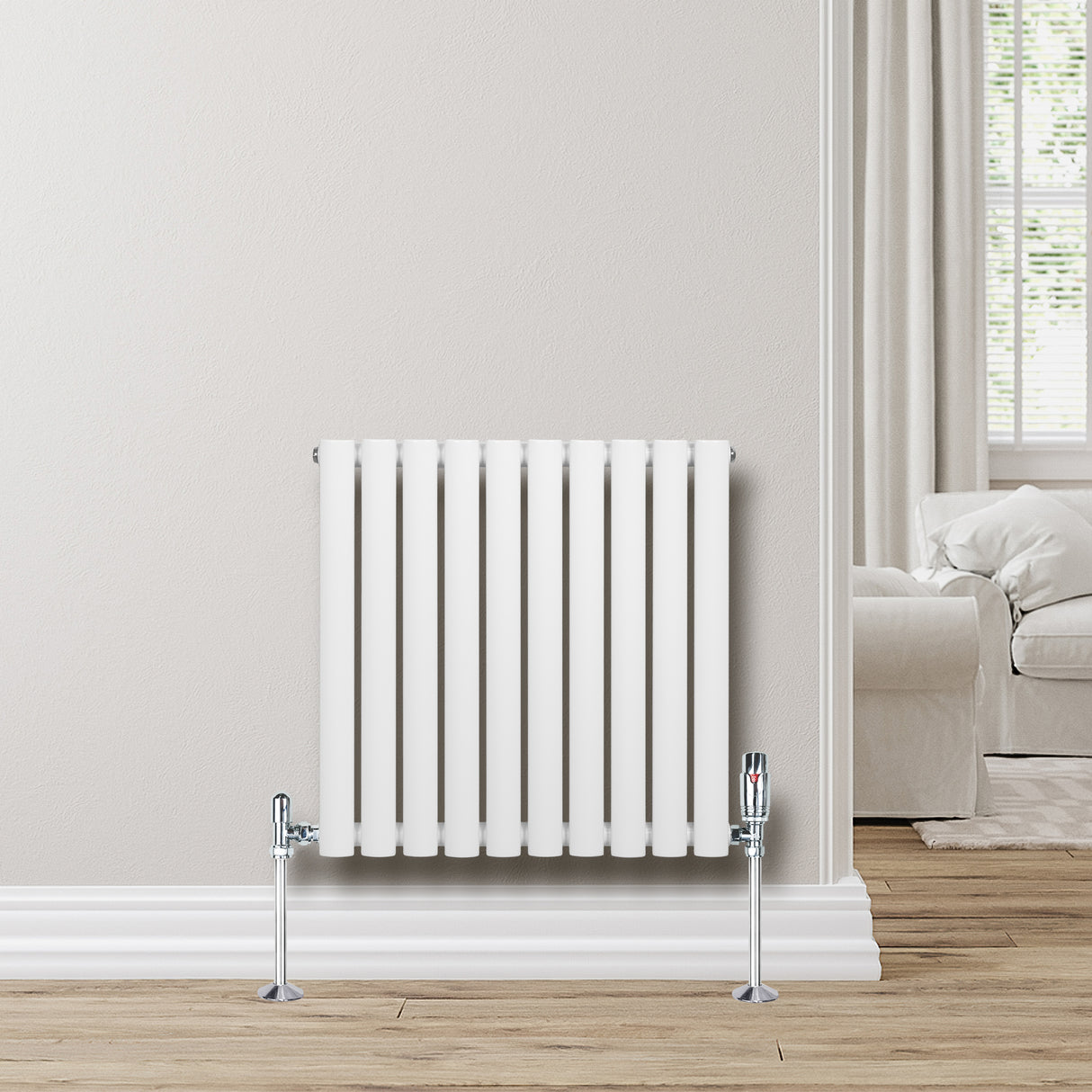 Sleek white oval single column radiator with chrome valves, mounted on a light-colored wall, enhancing modern interior decor