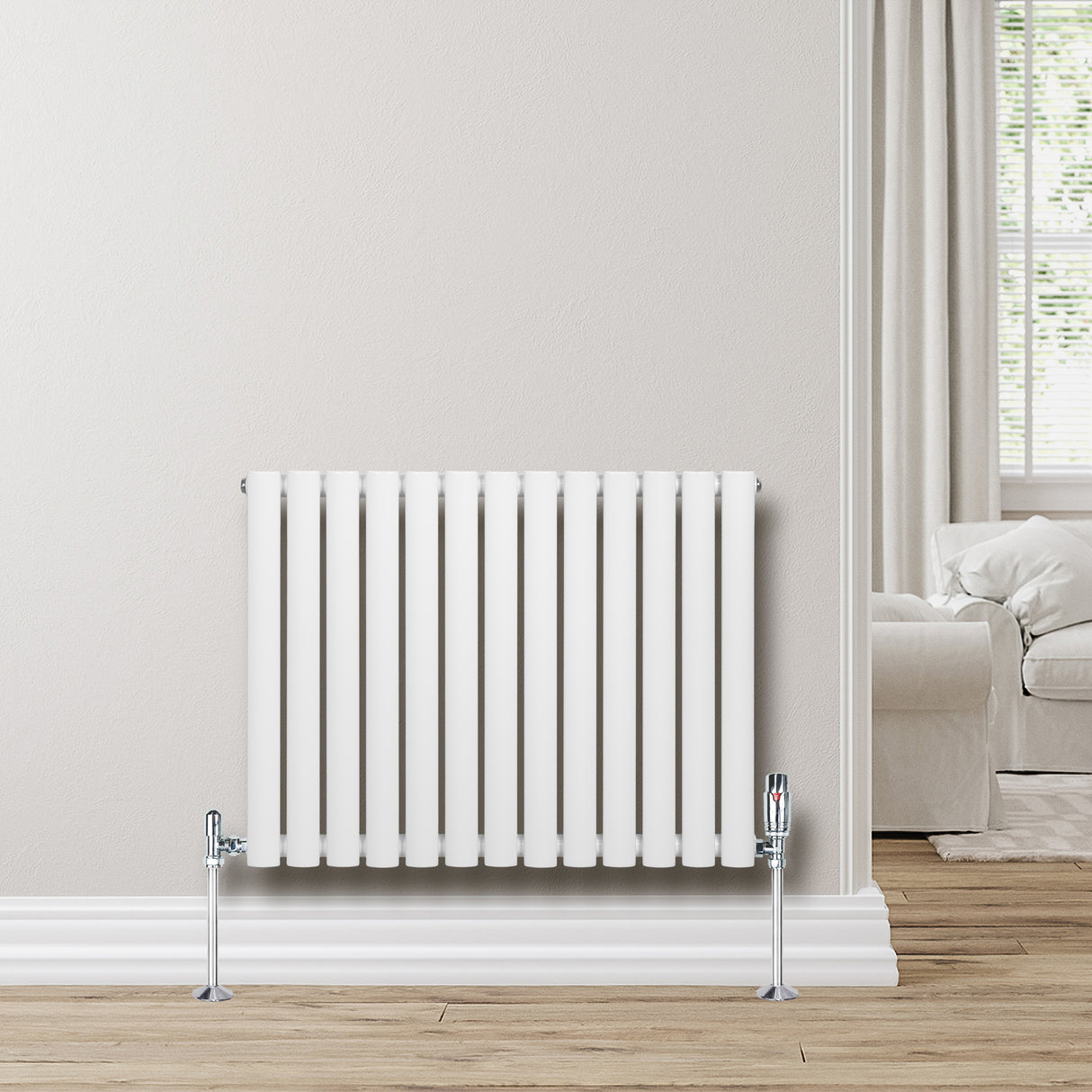 Sleek white oval single column radiator with chrome valves, positioned against a light wall, enhancing modern interior decor