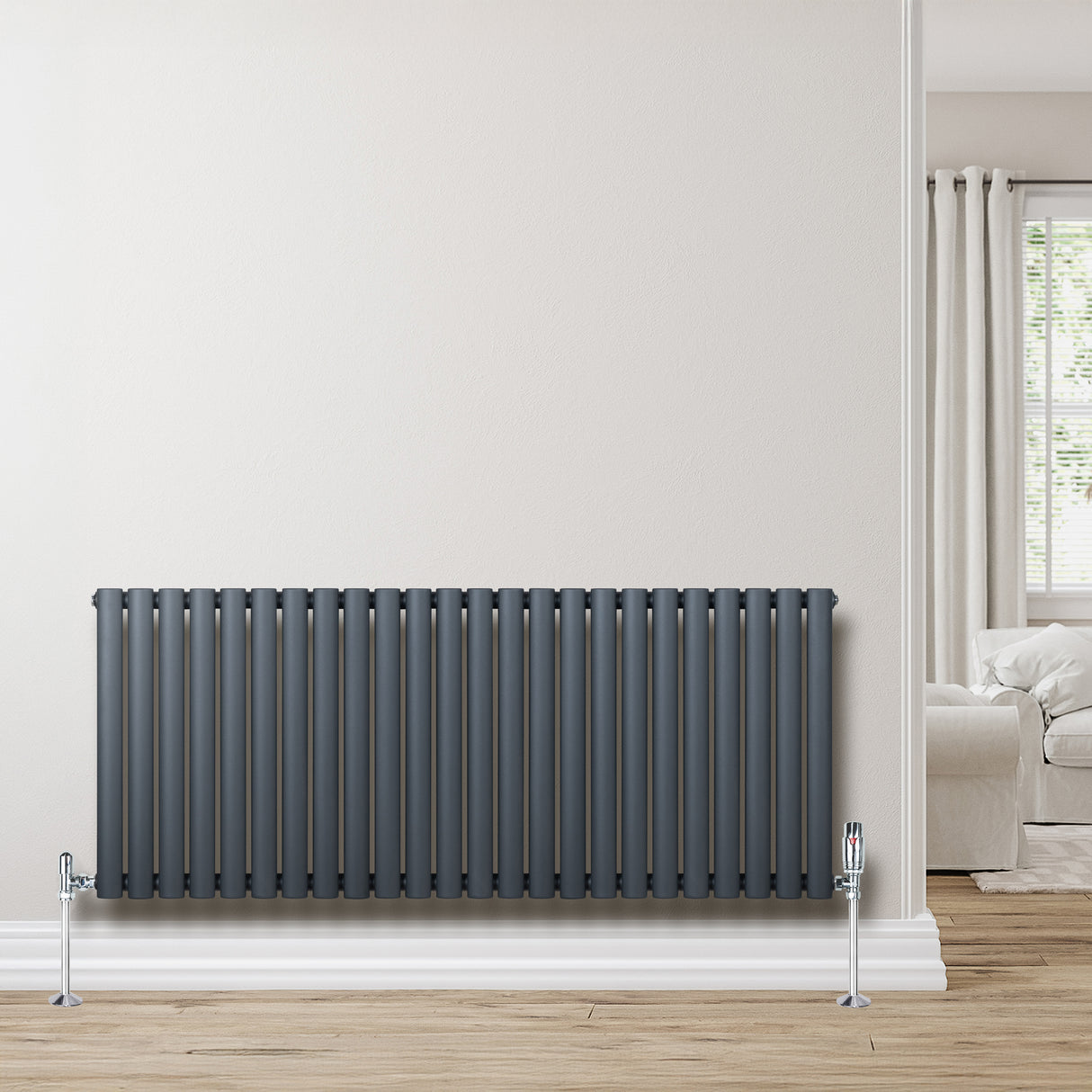 Anthracite grey oval single column radiator with sleek vertical lines, mounted against a light wall, enhancing modern interior decor