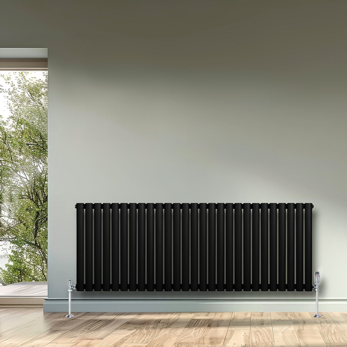 Sleek black oval single column radiator with chrome valves, positioned against a light gray wall and wooden floor, enhancing modern decor