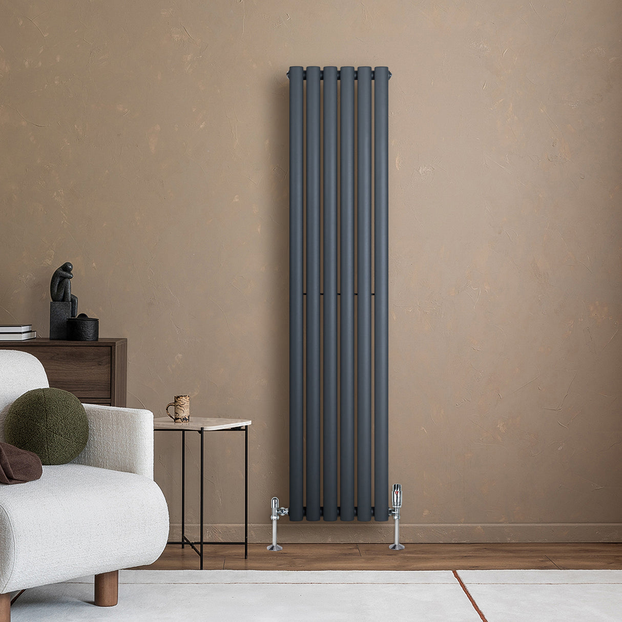 Anthracite grey oval single column radiator with sleek vertical lines, complemented by modern valves, against a warm beige wall