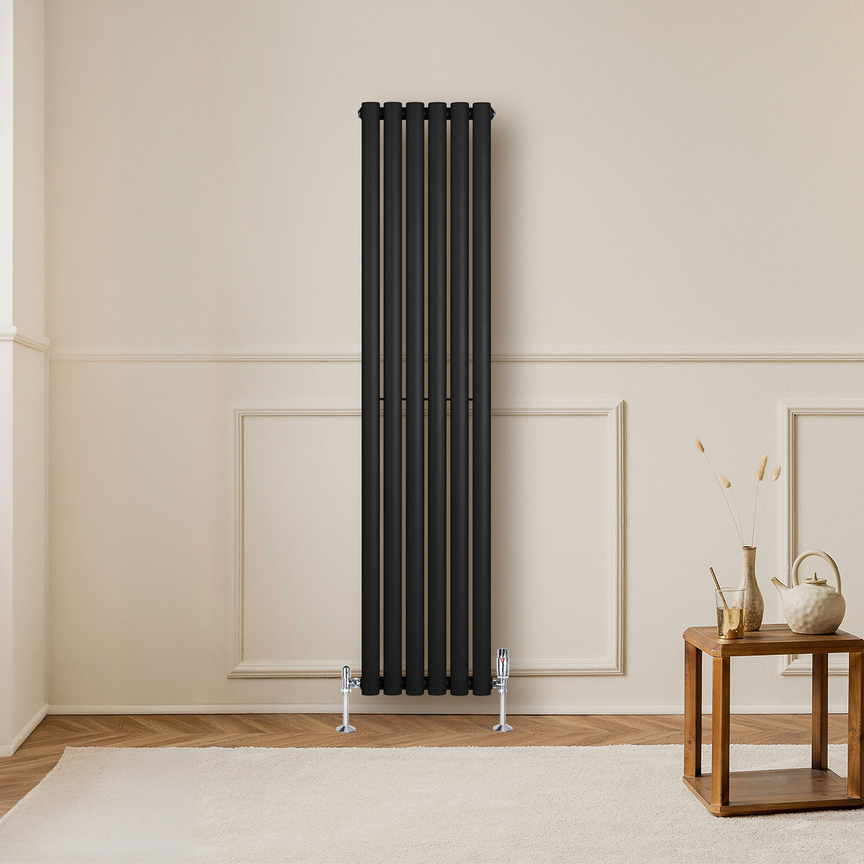 Sleek black oval single column radiator with polished valves, mounted on a light wall, enhancing modern interior decor
