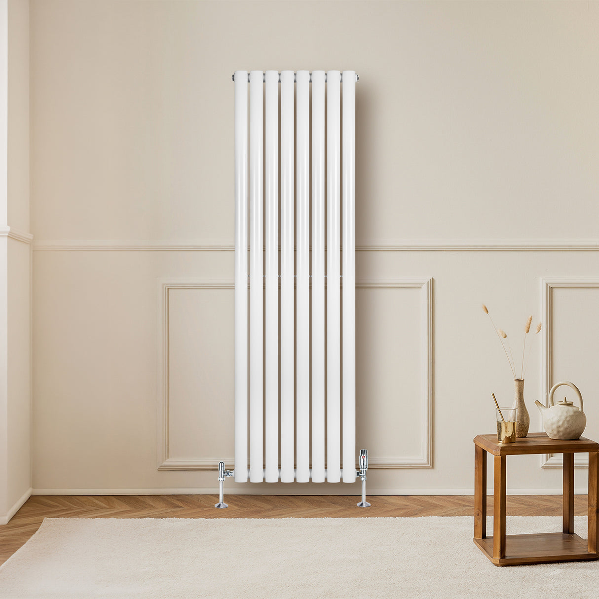 Sleek white oval single column radiator stands tall against a neutral wall, enhancing a cozy living space with elegant design