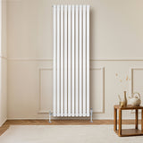Sleek white oval single column radiator, 1800mm x 600mm, mounted on a wall, with elegant valves and a modern wooden table nearby