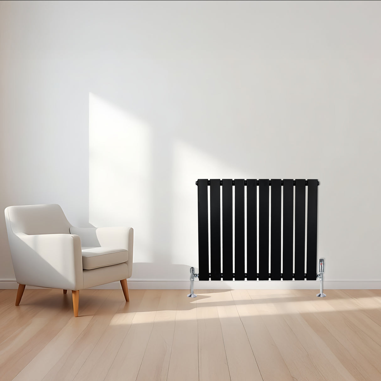 Sleek black flat single column radiator with chrome valves, positioned beside a modern white armchair in a bright room