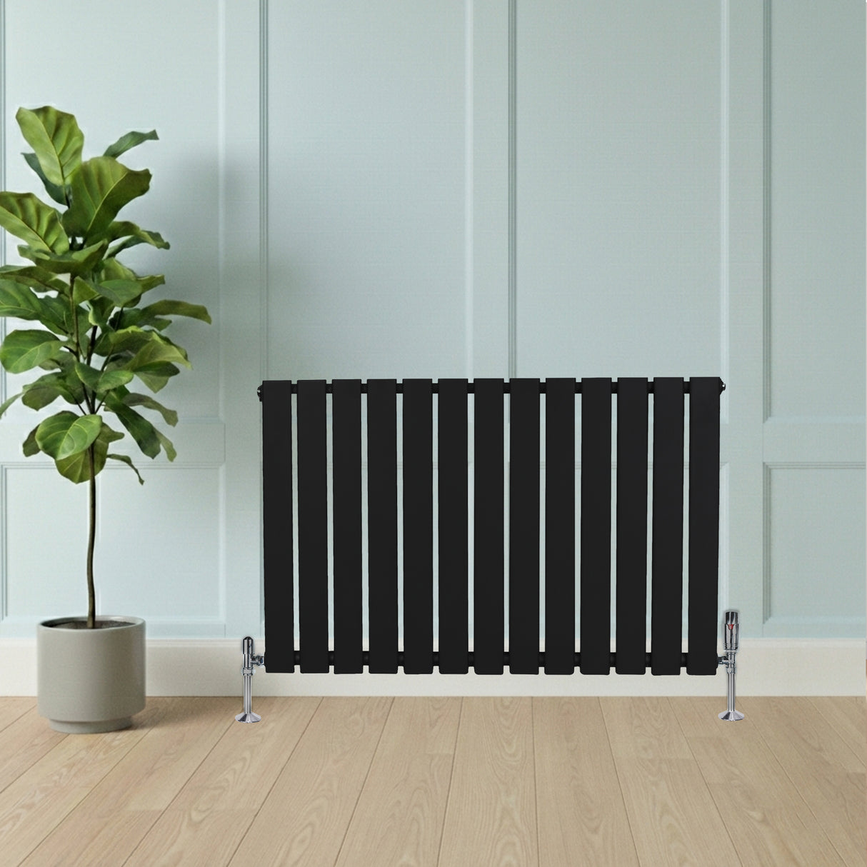 Sleek black flat single column radiator with vertical slats, complemented by chrome valves, set against a light blue wall and wooden floor