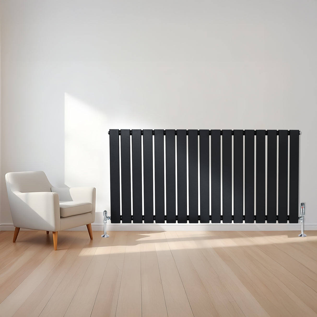 Sleek black flat single column radiator with polished valves, positioned beside a modern white armchair in a bright room