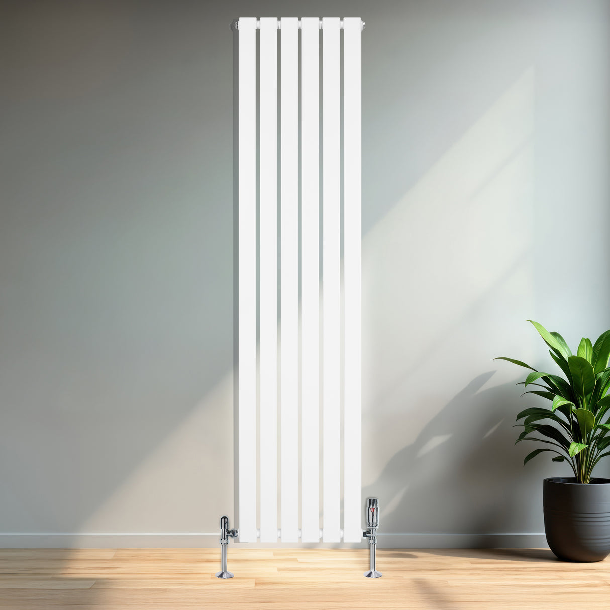 Tall, sleek white flat single column radiator with polished valves, set against a modern interior with wooden flooring and a green plant
