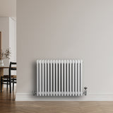 Traditional white 4 column radiator with a smooth finish, mounted on a light wall, featuring chrome valves and a sleek design