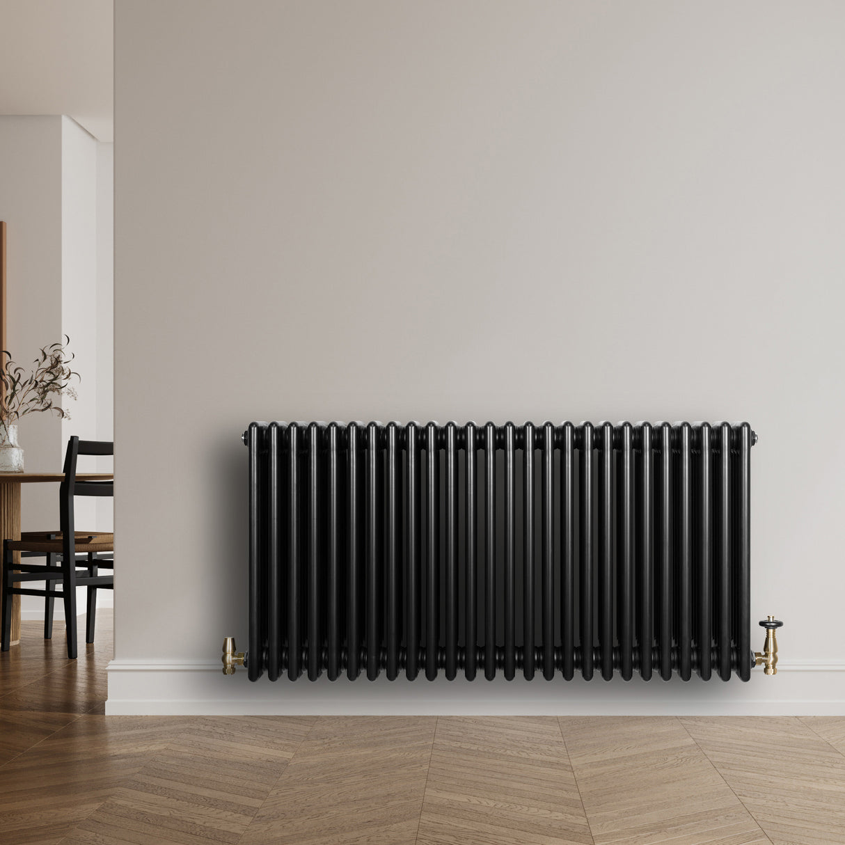 Traditional black 4 column radiator with a sleek finish, mounted on a wall, featuring brass valves and a modern interior setting