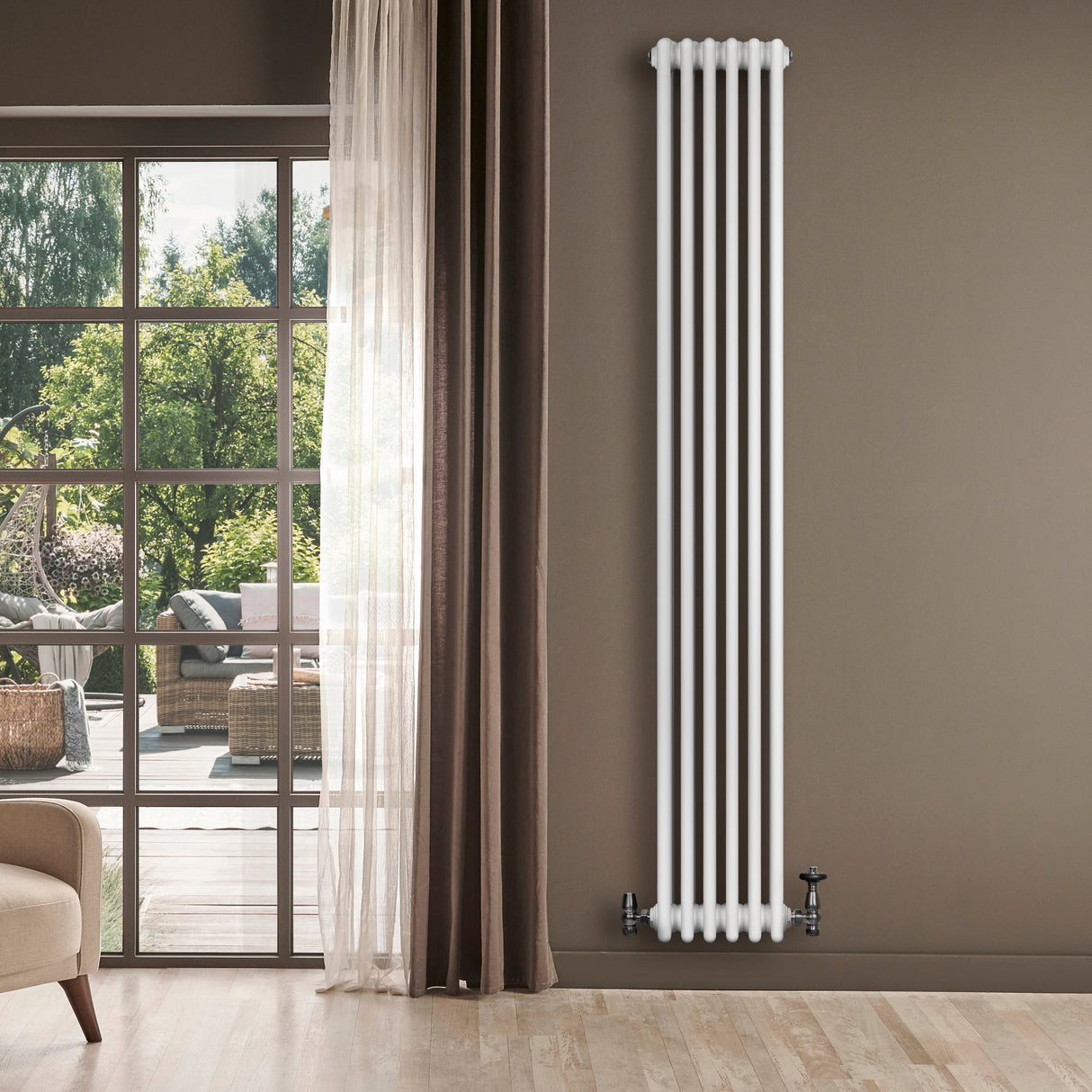 Tall, white traditional 4 column radiator with valves, mounted on a wall, surrounded by natural light and a cozy interior setting