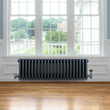 Traditional anthracite 4 column radiator, 300 x 1010mm, featuring a sleek design with smooth, rounded edges, mounted beneath a large window