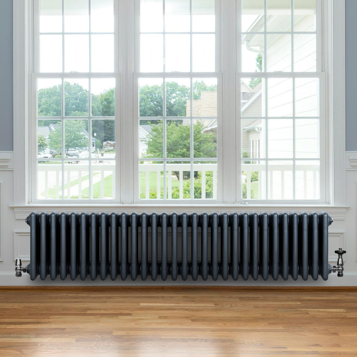 Traditional anthracite 4 column radiator, 300 x 1370mm, featuring a sleek design with a smooth finish, positioned under a large window