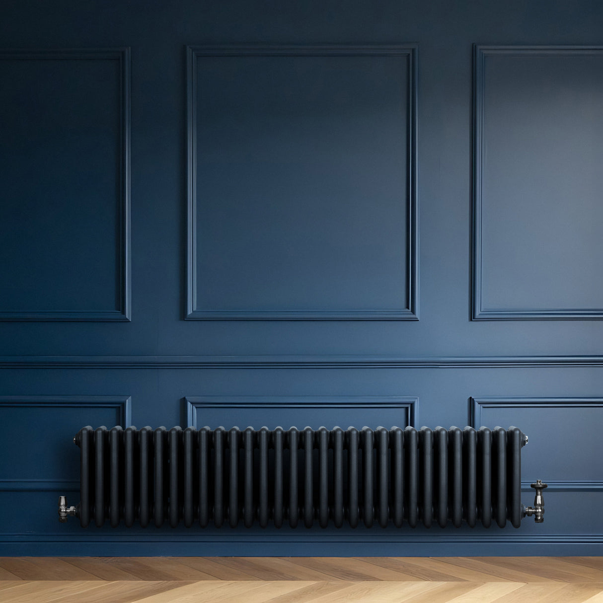 Traditional anthracite 4 column radiator mounted on a deep blue wall, featuring a sleek, ribbed design and polished metal valves