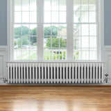 Traditional white 4 column radiator, 300 x 1505mm, featuring a smooth finish and sleek design, positioned under a large window