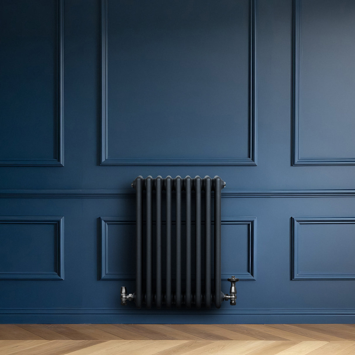 Traditional anthracite grey 4 column radiator mounted on a deep blue wall, featuring sleek lines and a modern design