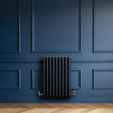 Traditional anthracite grey 4 column radiator mounted on a deep blue wall, featuring sleek lines and a modern design