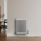 Traditional white 4-column radiator with a smooth finish, mounted on a light wall, enhancing a modern interior space