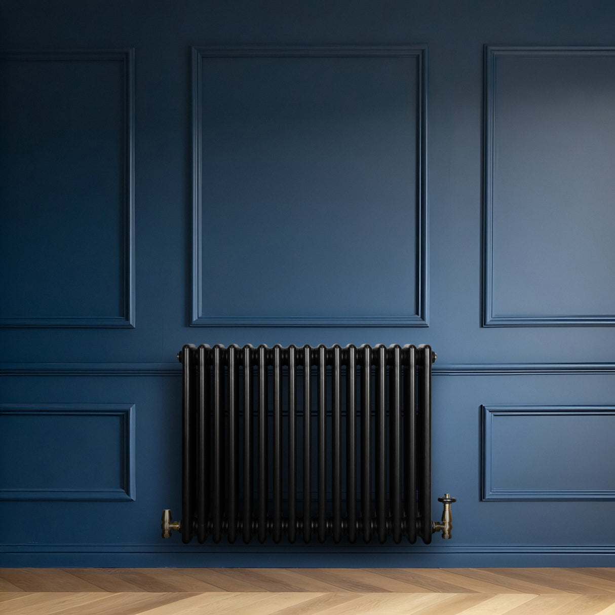 Traditional black 4 column radiator against a deep blue wall, featuring sleek vertical lines and a classic design with brass fittings
