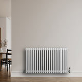 Traditional white 4 column radiator, 600 x 1010mm, featuring smooth, glossy finish and sleek vertical lines, mounted on a light wall