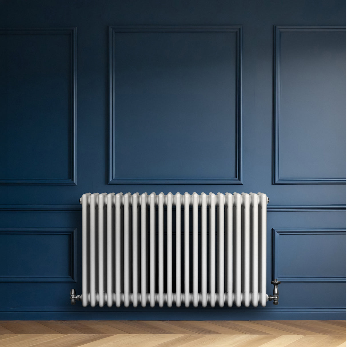 Traditional white 4 column radiator with a sleek design, mounted on a dark blue wall, showcasing smooth, glossy finish and elegant lines