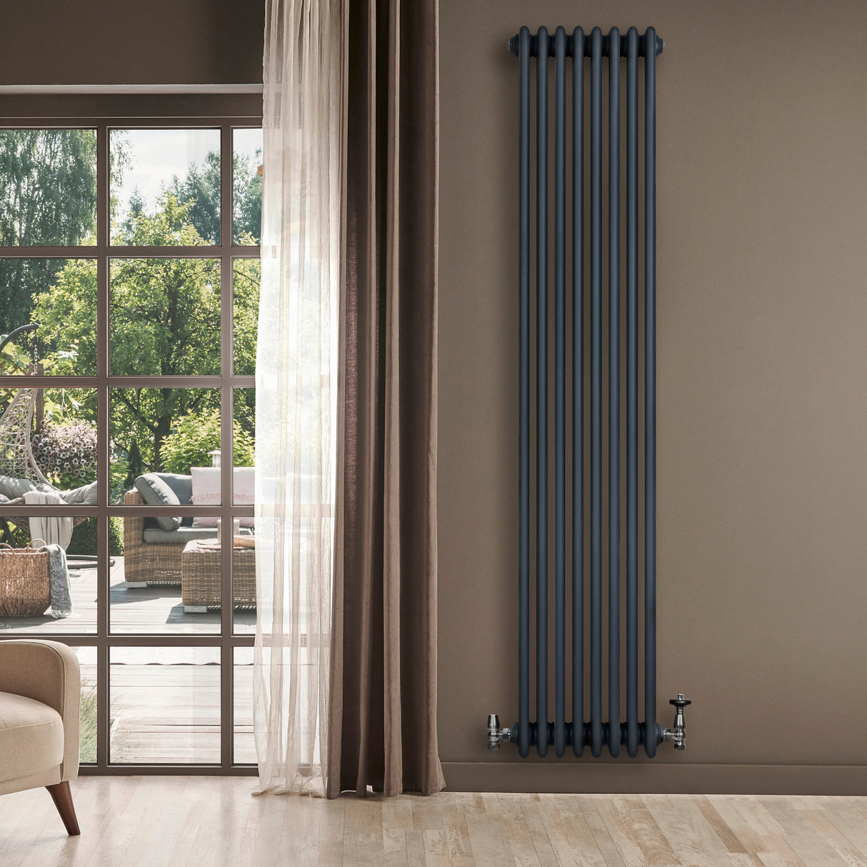 Tall anthracite grey traditional 4 column radiator against a light wall, featuring sleek vertical lines and a modern design