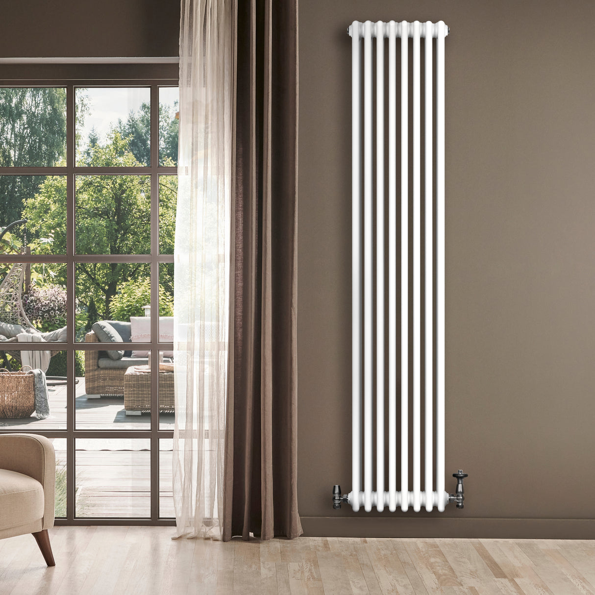 Tall, sleek white traditional 4 column radiator against a modern interior backdrop with large windows and natural light