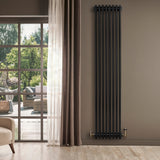Traditional black 4 column radiator, 1800 x 380mm, mounted on a wall, complementing a modern interior with natural light and greenery outside