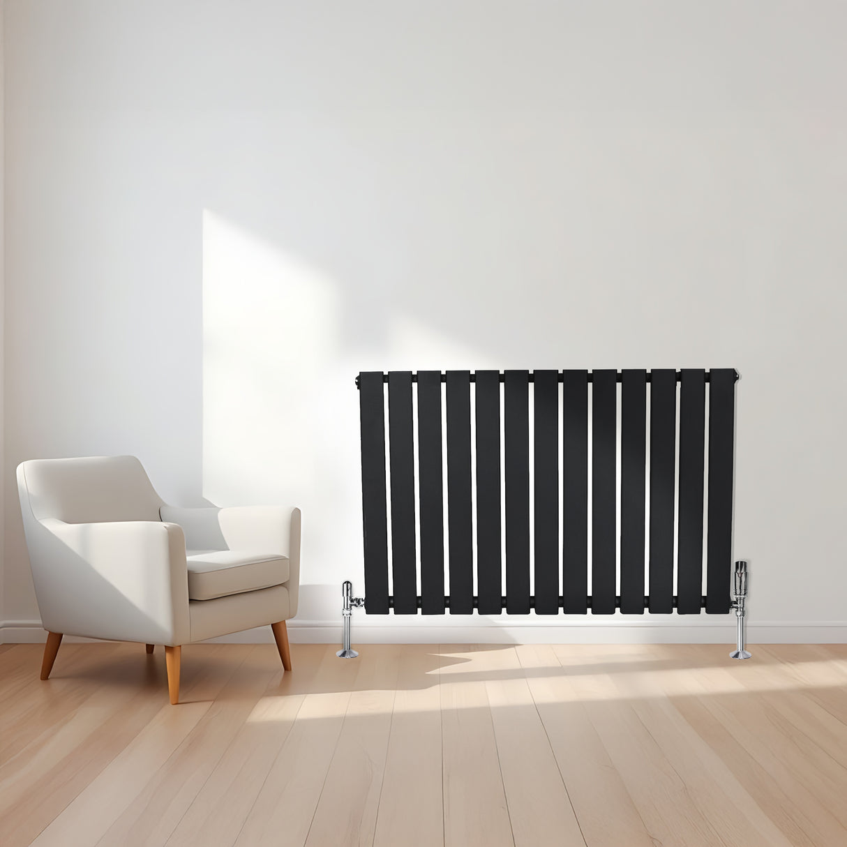 Sleek black flat single column radiator with vertical slats, positioned beside a modern white armchair on light wooden flooring