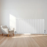 Sleek white flat single column radiator, 600 x 1190mm, mounted on a light wooden floor, beside a modern armchair in a bright room