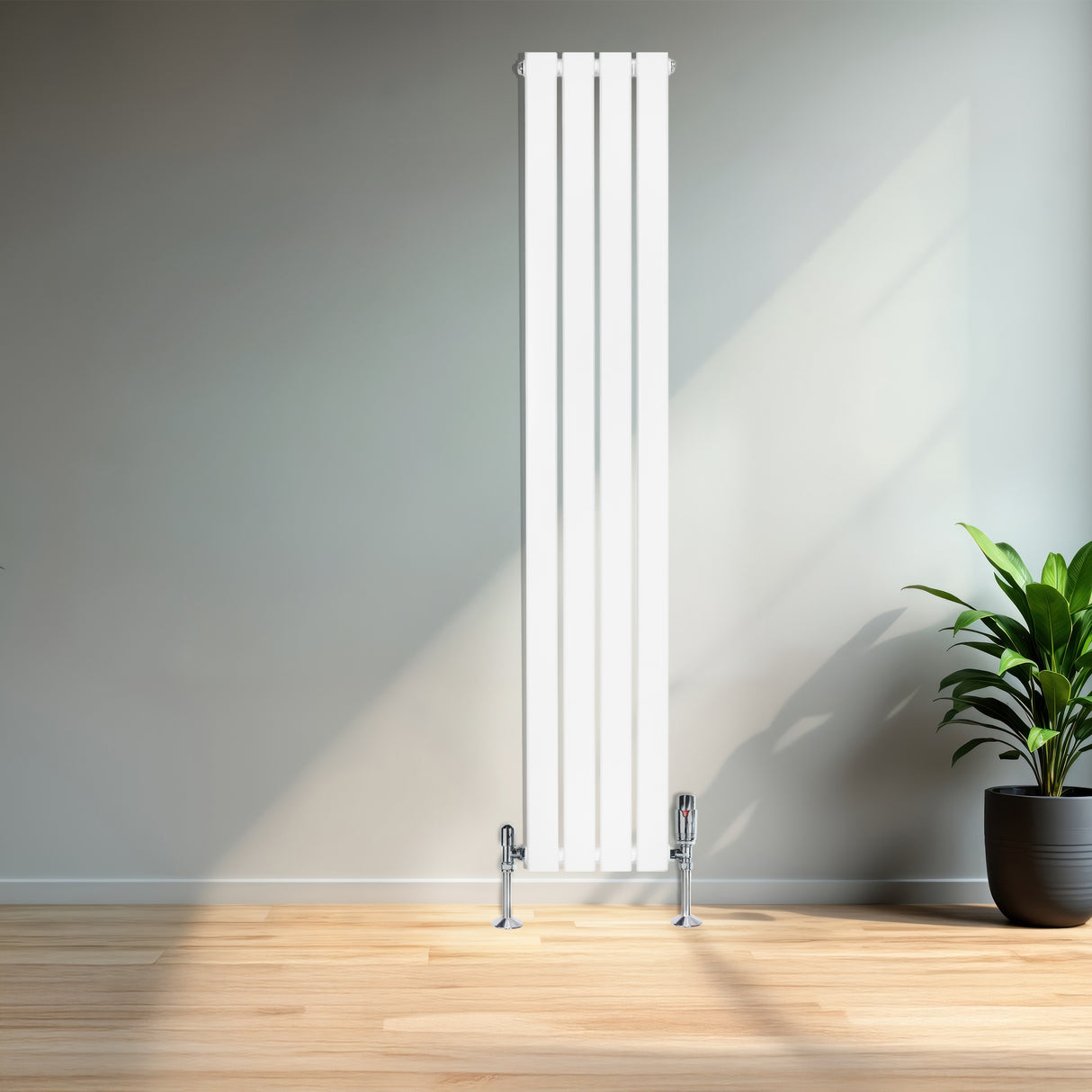 Sleek white flat single column radiator, 1600 x 280mm, mounted on a wall with chrome valves, complemented by a green potted plant