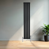 Sleek black flat single column radiator, 1600 x 280mm, mounted on the wall with chrome valves, set against a modern interior backdrop