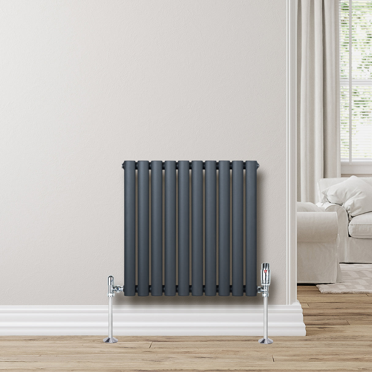 Anthracite grey oval single column radiator with sleek vertical lines, mounted on a light wall, enhancing modern interior decor