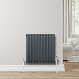Anthracite grey oval single column radiator with sleek vertical lines, mounted on a light wall, enhancing modern interior decor