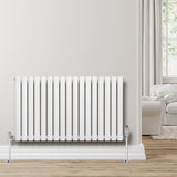Sleek white oval single column radiator, 600 x 1020mm, mounted on a light-colored wall, complementing a cozy living room setting