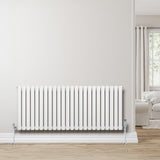 Sleek white oval single column radiator, 600 x 1440mm, mounted on a light wall, complementing a cozy living room setting