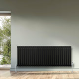 Sleek black oval single column radiator, 600 x 1620mm, mounted on a light wall, enhancing modern interior decor with a minimalist design