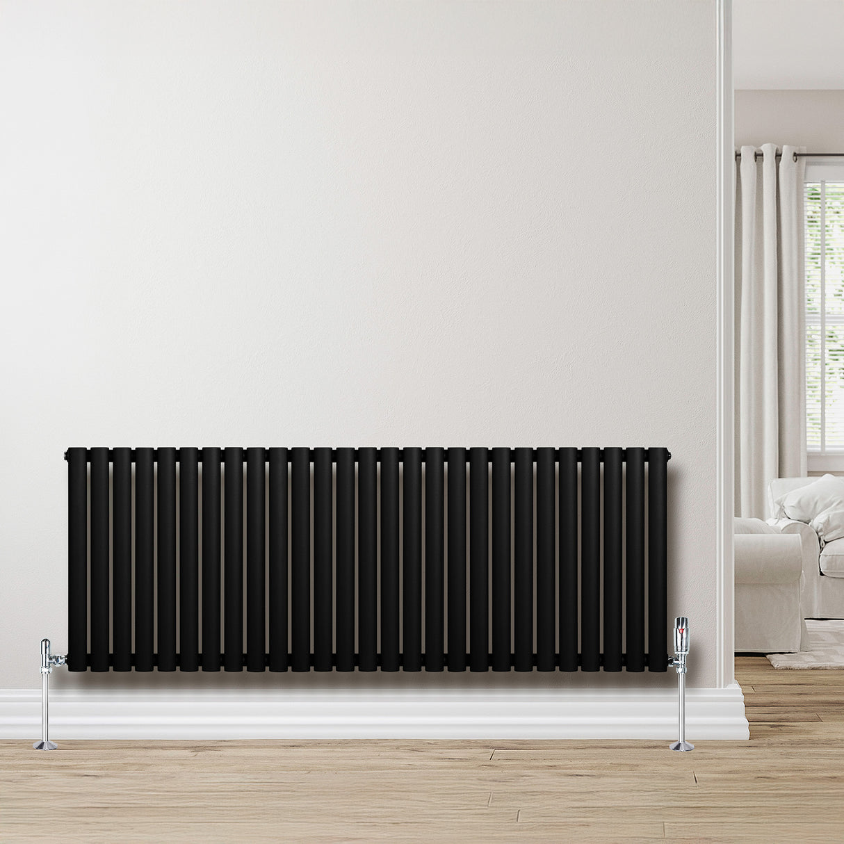 Sleek black oval single column radiator, 600 x 1620mm, mounted on a light wall, complementing a modern interior with wooden flooring